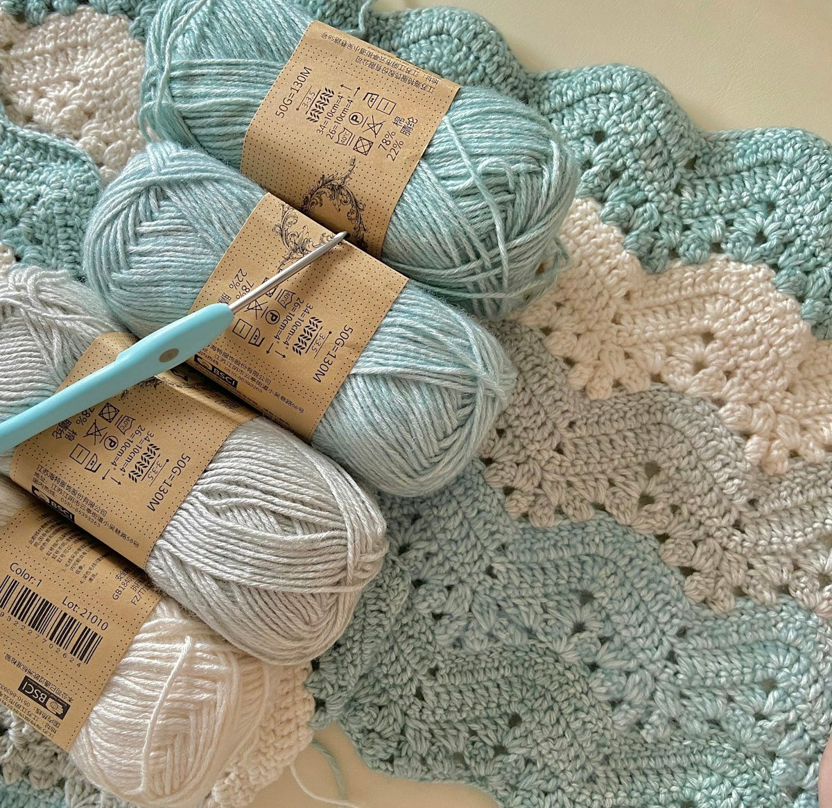 Pale blue and ivory yarn on a crochet blanket.